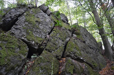 Kolmo rozpukané vrstvy vyvřelé lávy se zbytky výplně lávového tunelu na vrcholu.